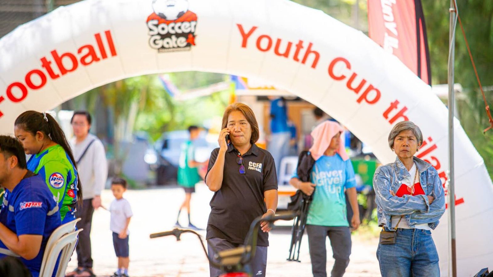 ทีมงาน CCFA เดินผ่านซุ้มโค้ง CCFA Football Youth Cup ในวันแข่งขัน
