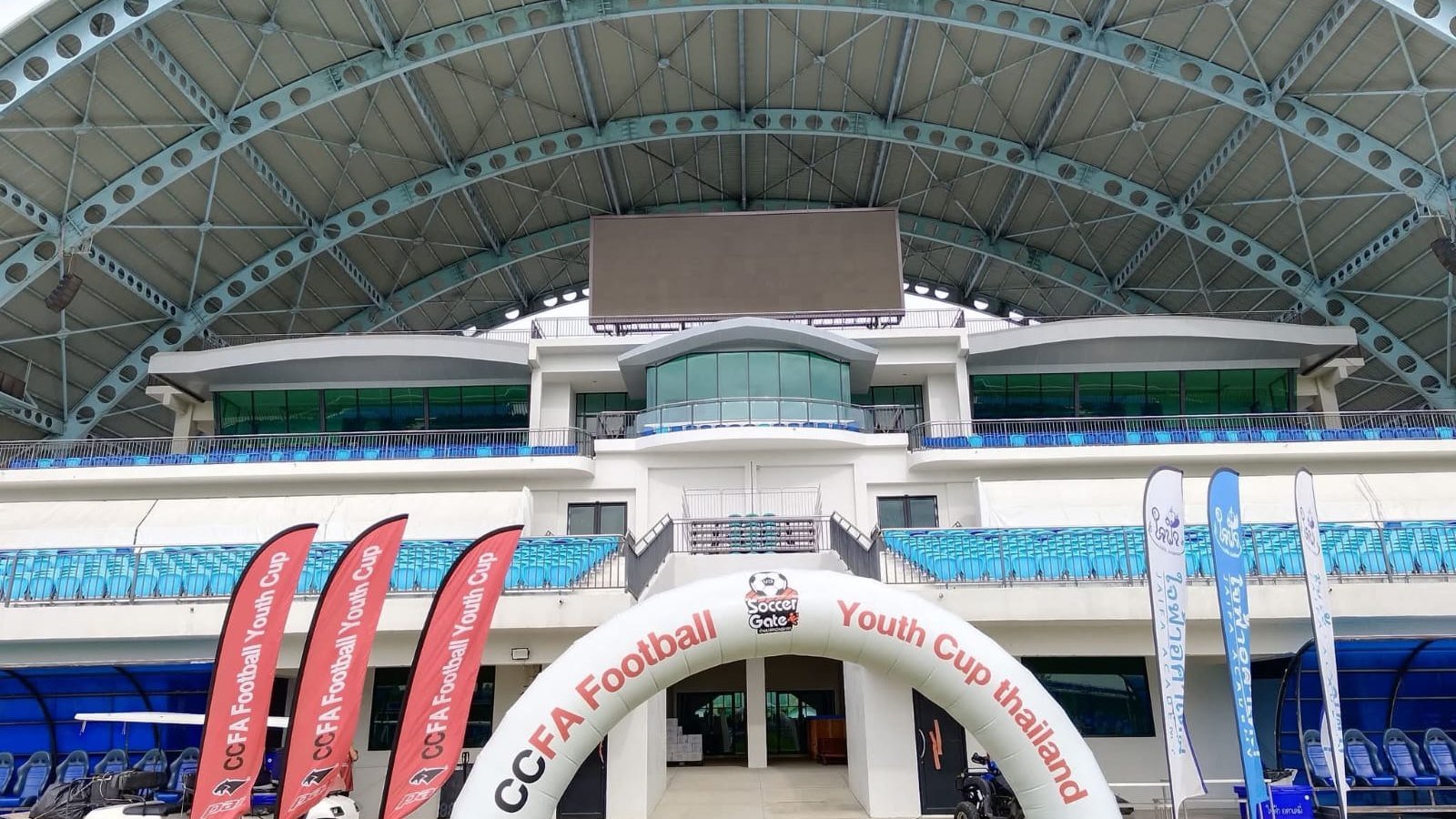ซุ้มโค้งและธงของ CCFA Football Youth Cup ติดตั้งบนสนามในสนามกีฬาที่มีหลังคา